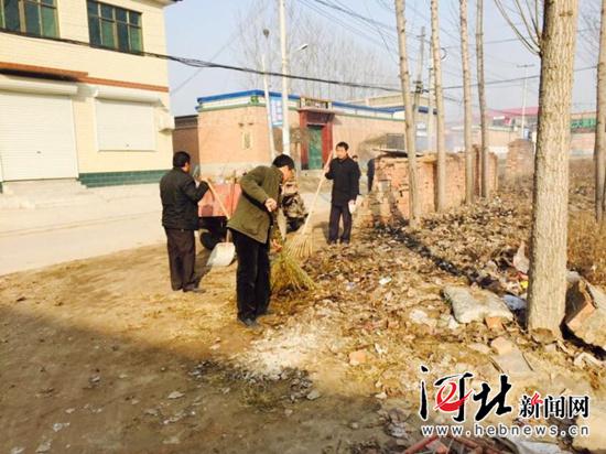 冬天和村民一起清理街道垃圾，右一為梁棟軍