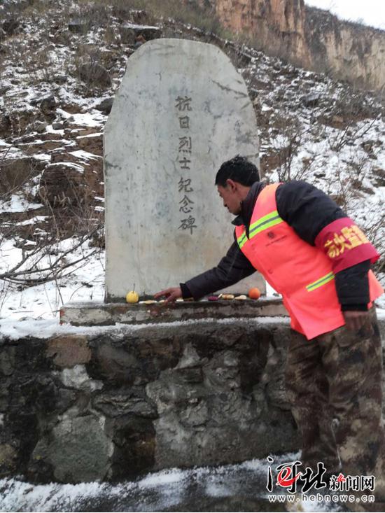 劉海清在烈士墓前擺放貢品。張長(zhǎng)江攝